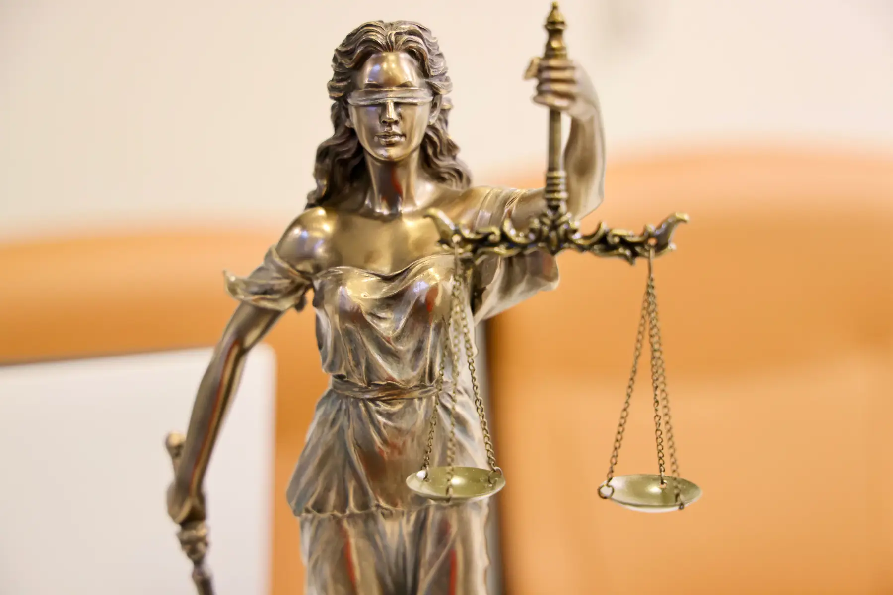 Bronze Lady Justice statue holding balanced scales