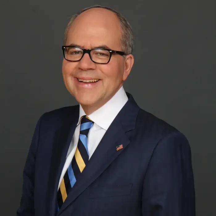 Professional portrait of attorney Peter James Johnson in a navy suit and striped tie